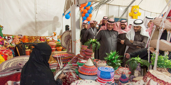  عدد من أعضاء المجلس المحلي أمام سيدة حرفية بمهرجان الخبر