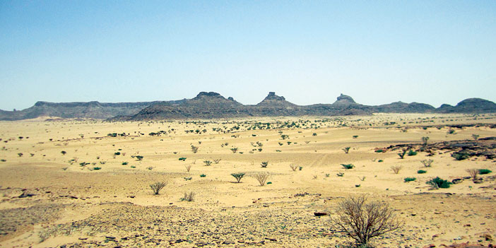  جبال سنامة وأمامها واد ممتد مليء بأشجار السمر